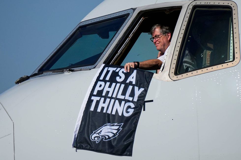 A Philadelphia Eagles flag is held as the team arrives ahead of Super Bowl 57, Sunday, Feb. 5, 2023, in Phoenix.