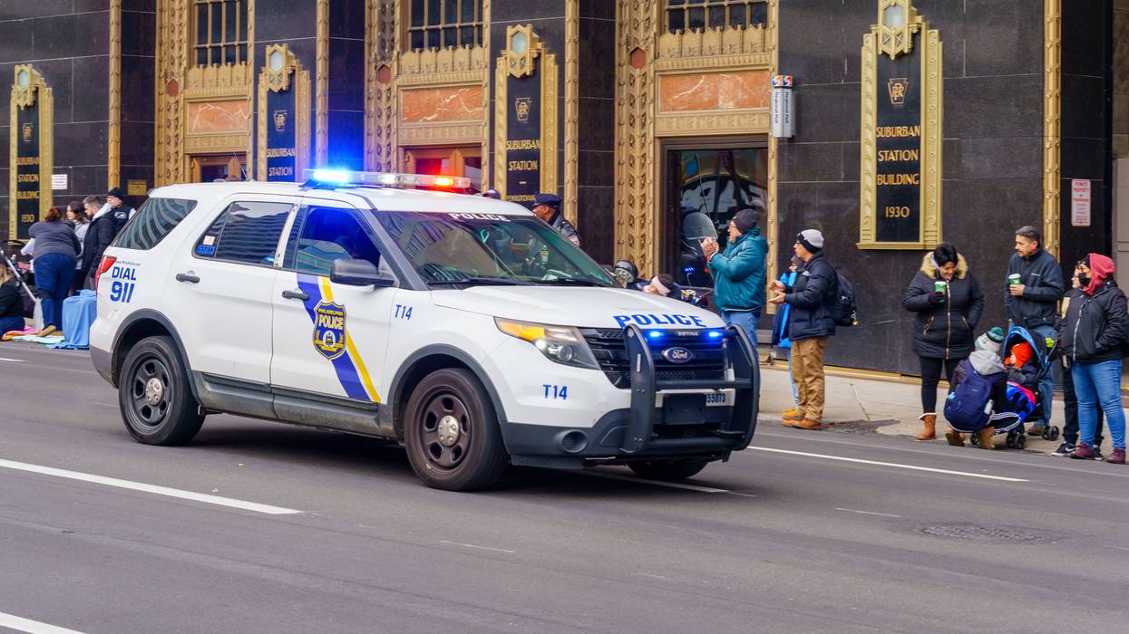 A Philadelphia Police Department vehicle in front of Suburban Station with its emergency lights activated.