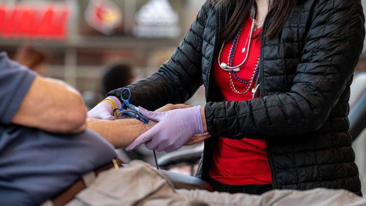 A phlebotomist tends to the arm of a blood donor at the KFC YUM! Center during the Starts, Stripes, and Pints blood drive event on July 7, 2021 in Louisville, Kentucky.
