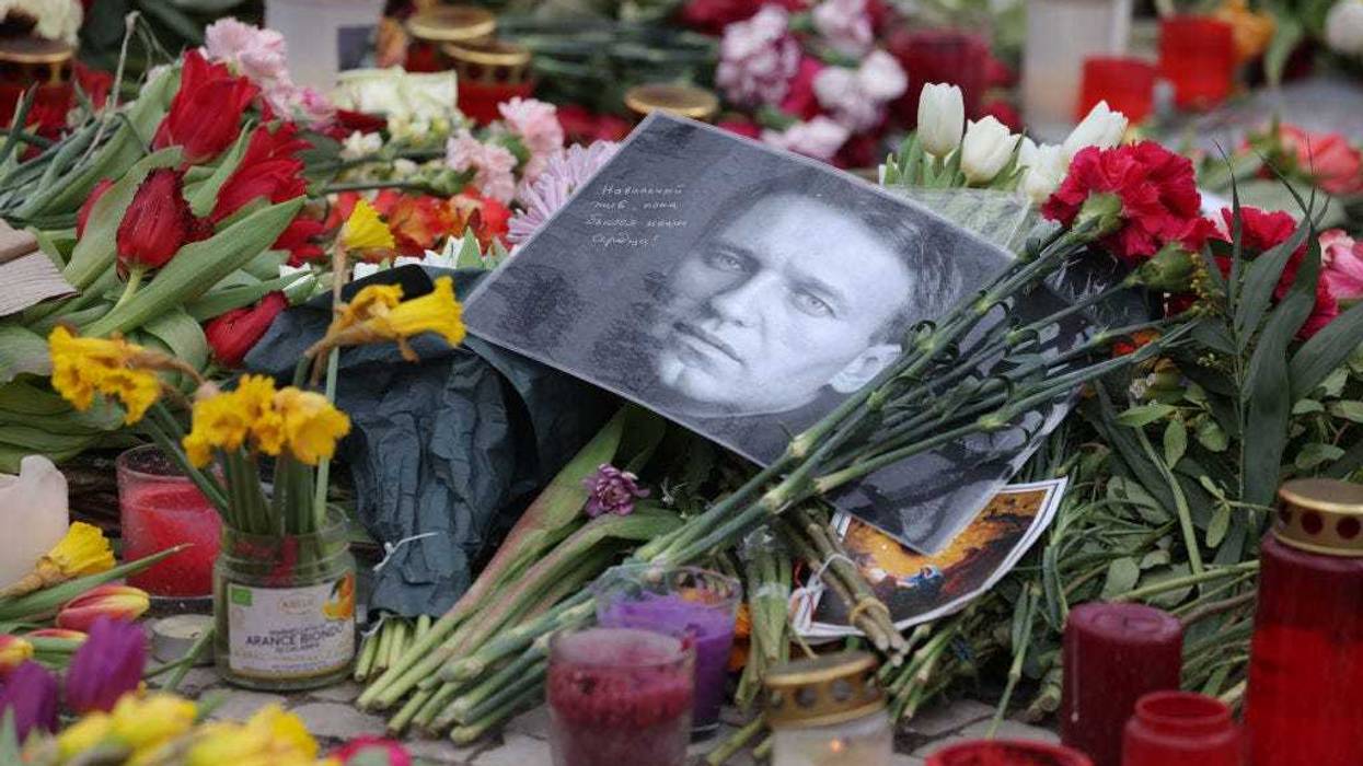 A photo of Russian opposition figure Aleksei Navalny lies among candles and flowers at a makeshift memorial to him in front of the Russian Embassy on February 24, 2024 in Berlin, Germany.