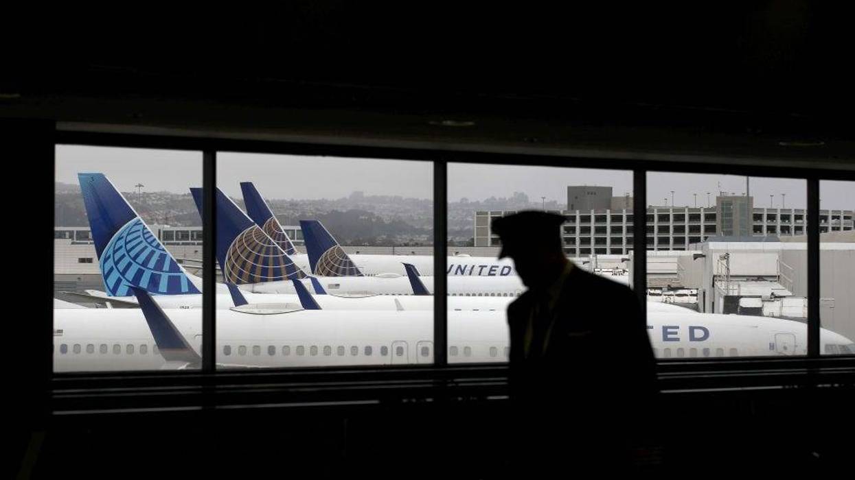 A pilot walks by United Airlines planes as they sit parked at gates at San Francisco International Airport on April 12, 2020 in San Francisco, California.
