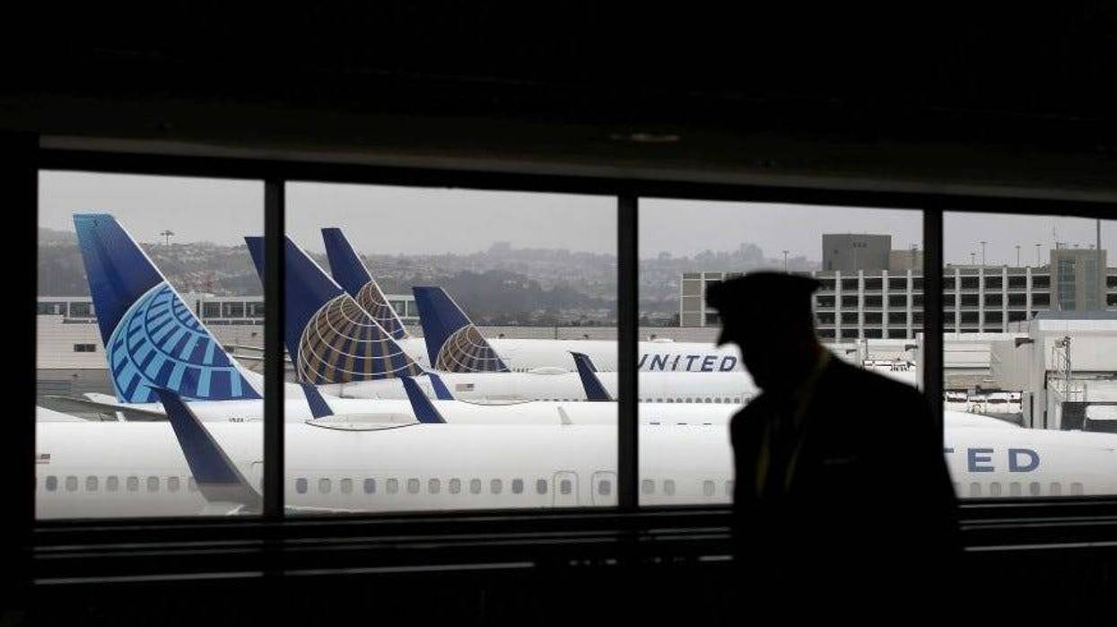 A pilot walks by United Airlines planes as they sit parked at gates at San Francisco International Airport on April 12, 2020 in San Francisco, California.