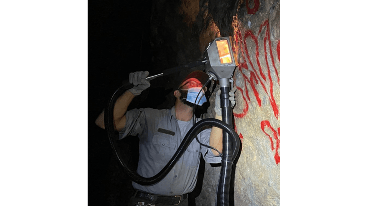 A Pinnacles National Park employee uses machinery to remove graffiti from the Balconies Caves.