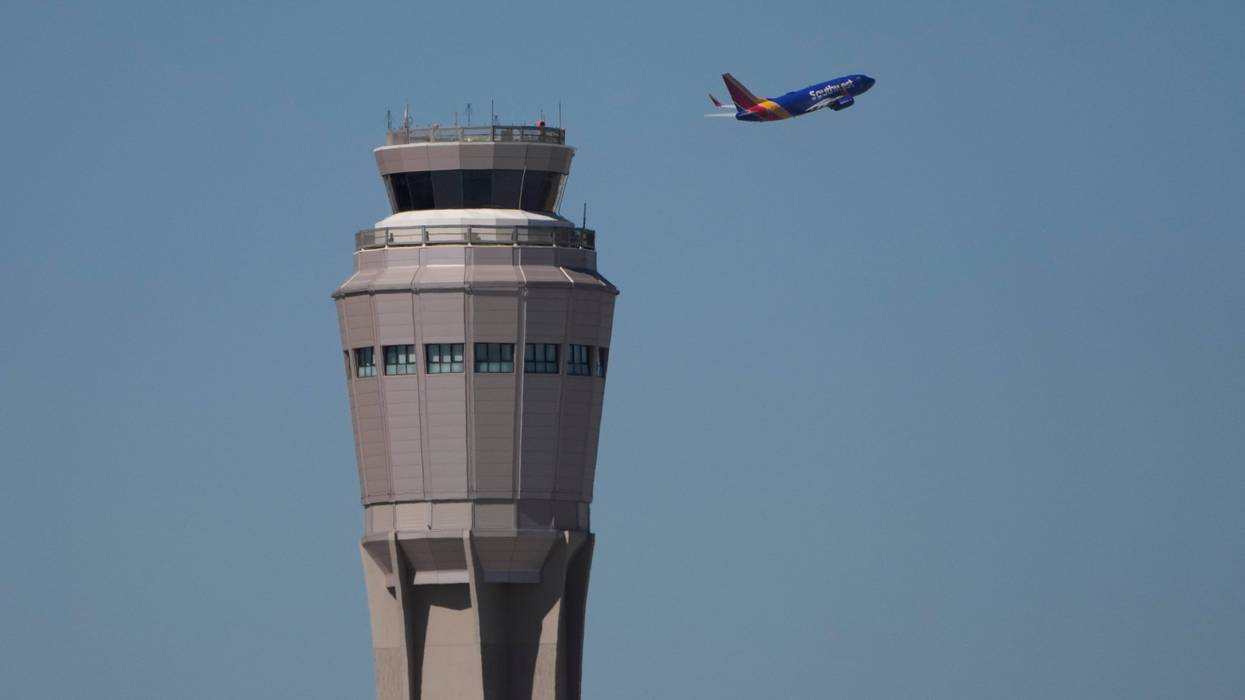 A plane takes off near the air traffic control tower at Harry Reid International Airport, Oct. 7, 2025, in Las Vegas.