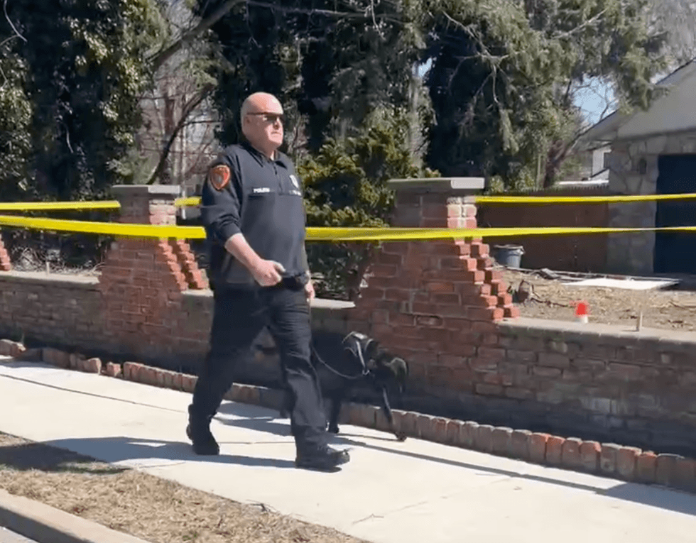 A police officer and canine are seen near Bruno Lane in Dix Hills amid the investigation on March 19