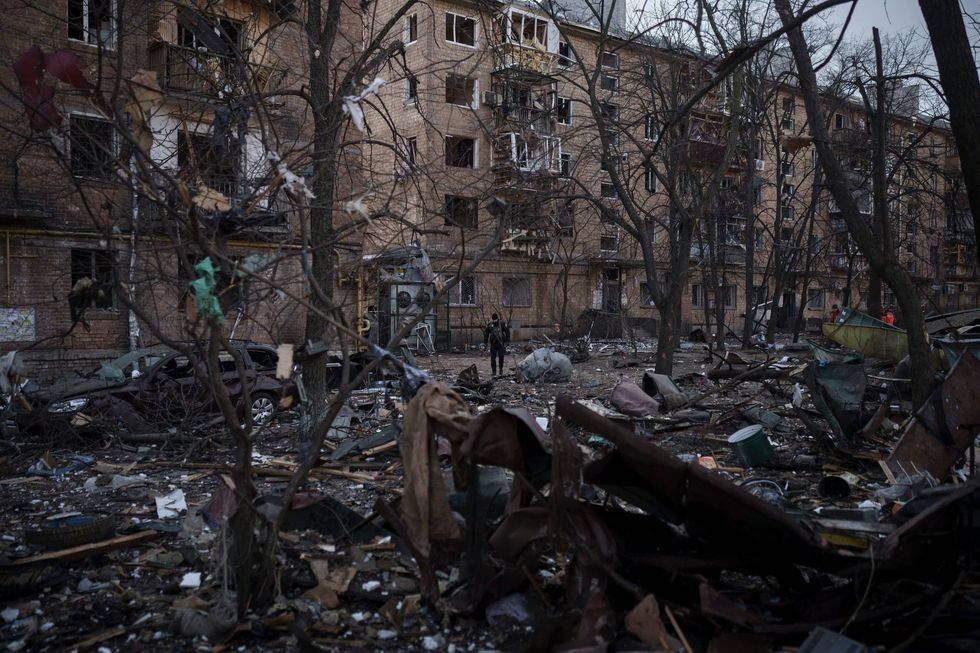 A police officer walks at the site of a bombing that damaged residential buildings in Kyiv, Ukraine, Friday, March 18, 2022. Russian forces pressed their assault on Ukrainian cities Friday, with new missile strikes and shelling on the edges of the capital Kyiv and the western city of Lviv, as world leaders pushed for an investigation of the Kremlin’s repeated attacks on civilian targets, including schools, hospitals and residential areas.