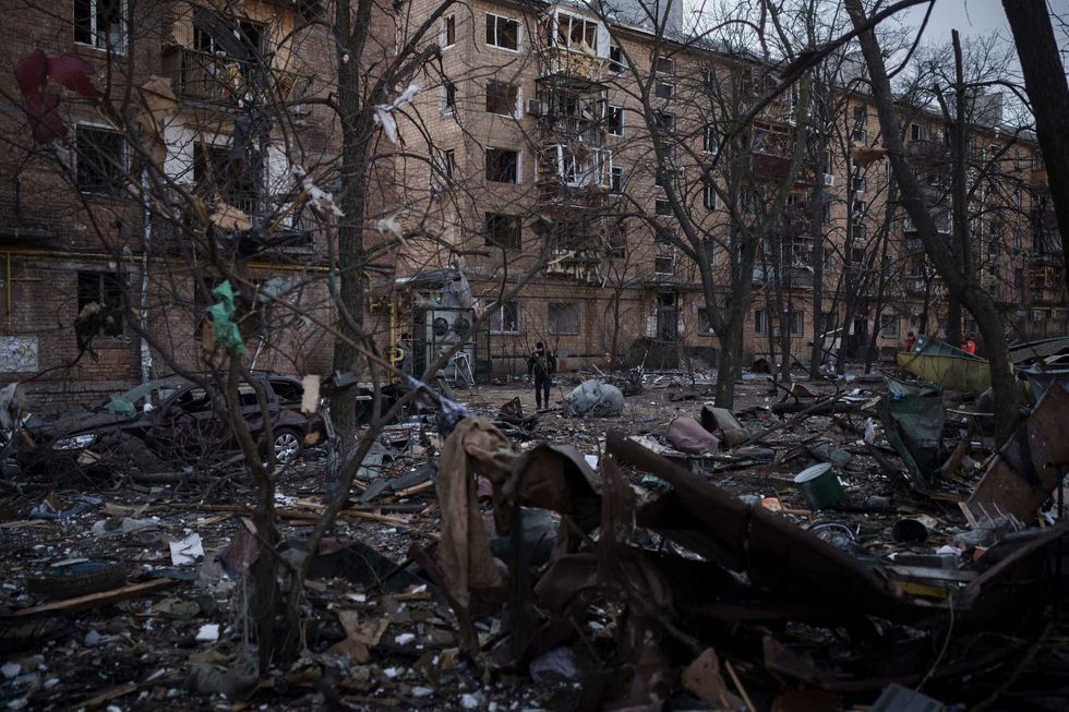 A police officer walks at the site of a bombing that damaged residential buildings in Kyiv, Ukraine, Friday, March 18, 2022