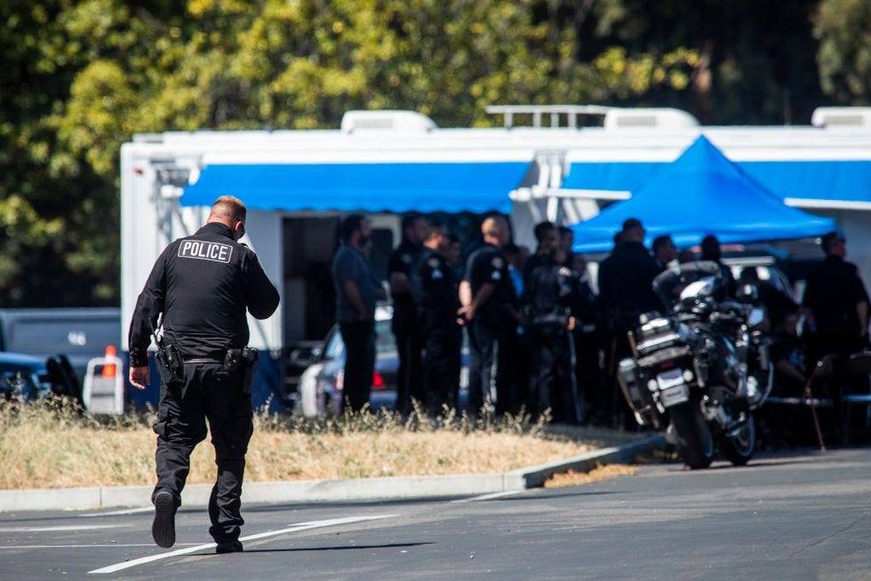 A police officer walks through a parking lot near the site of a mass shooting at a Valley Transportation Authority (VTA) light-rail yard on May 26, 2021 in San Jose, California.