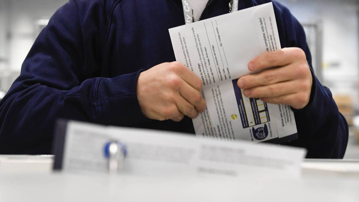 A poll worker handles a ballot.