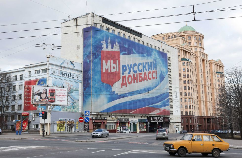 A poster reading "We are Russian Donbas" and bearing a Russian flag is pictured at a building in Donetsk, Ukraine. Denis Pushilin, head of the Donetsk People