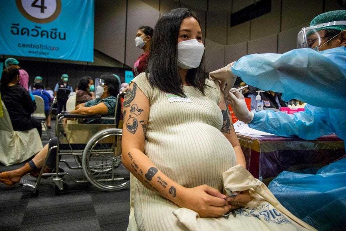 A pregnant woman receives her first dose of the Pfizer vaccine.