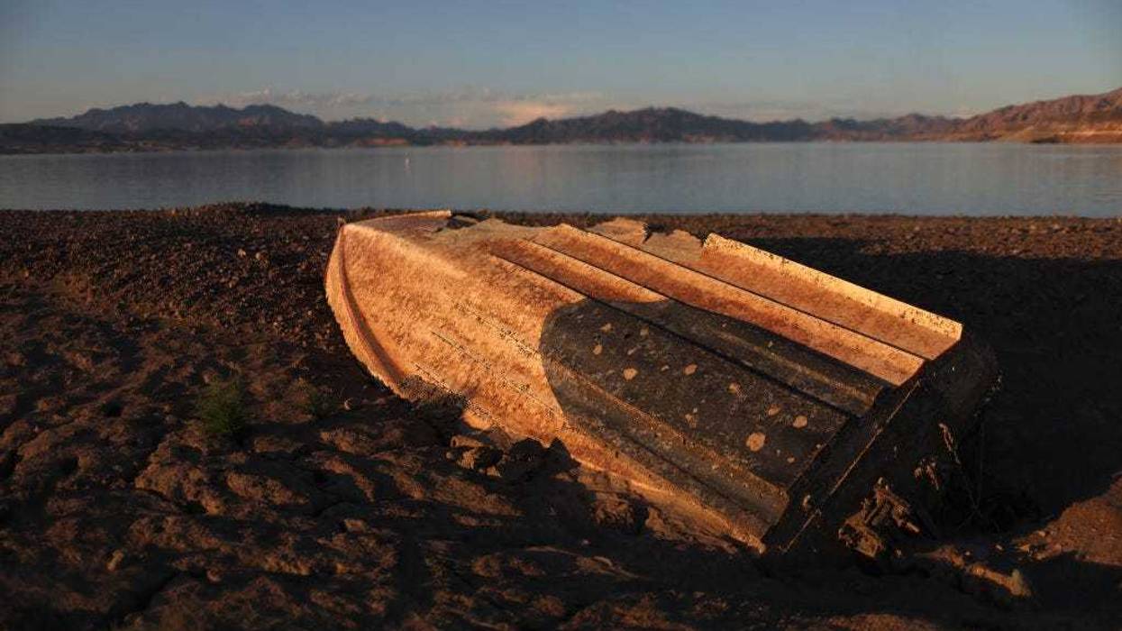 A previously sunken boat sits on the banks of Lake Mead on August 19, 2022 in Lake Mead National Recreation Area, Nevada. The boat belongs to Steve Buckalew, who said it crashed and sank during a water skiing competition in 1977.