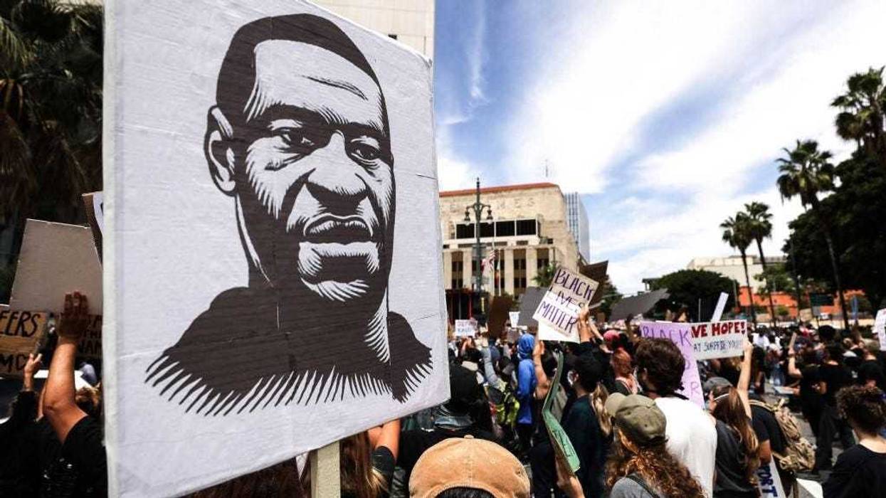 A protester holds a sign with an image of George Floyd during a peaceful demonstration over Floyd’s death outside LAPD headquarters on June 2, 2020 in Los Angeles, California.