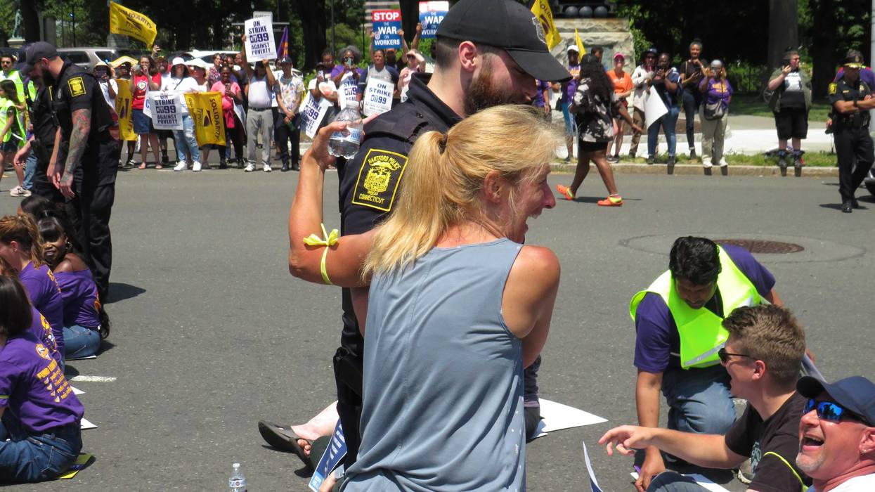 A protestor is arrested by Hartford police, 6/1/23. Police arrested 57 people for an act of civil disobedience-- sitting down on busy Capitol Ave. as part of a rally critical of state budget spending priorities