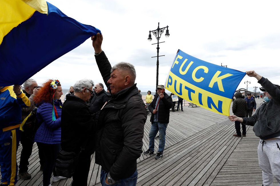A rally participant holds a Ukrainian flag as others listen to mostly Russian speakers denounce the war in the Ukraine on March 20, 2022 in the Brighton Beach section of the Brooklyn borough of New York City.