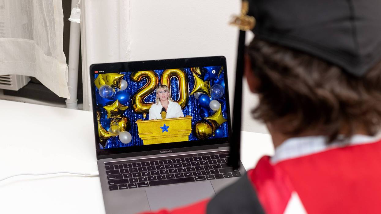 A recent graduate watches Miley Cyrus perform during a virtual graduation ceremony held by Facebook from his laptop on May 15, 2020 in New York City.