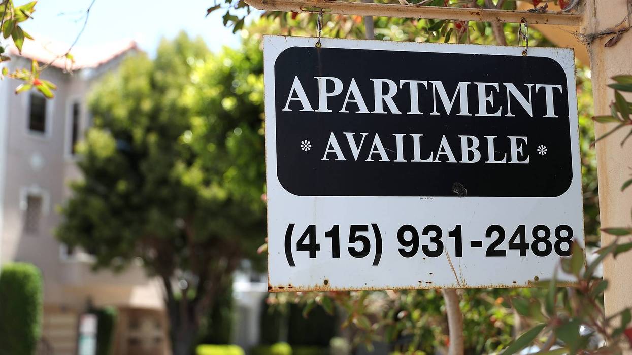 A rental vacancy sign is posted in front of an apartment.