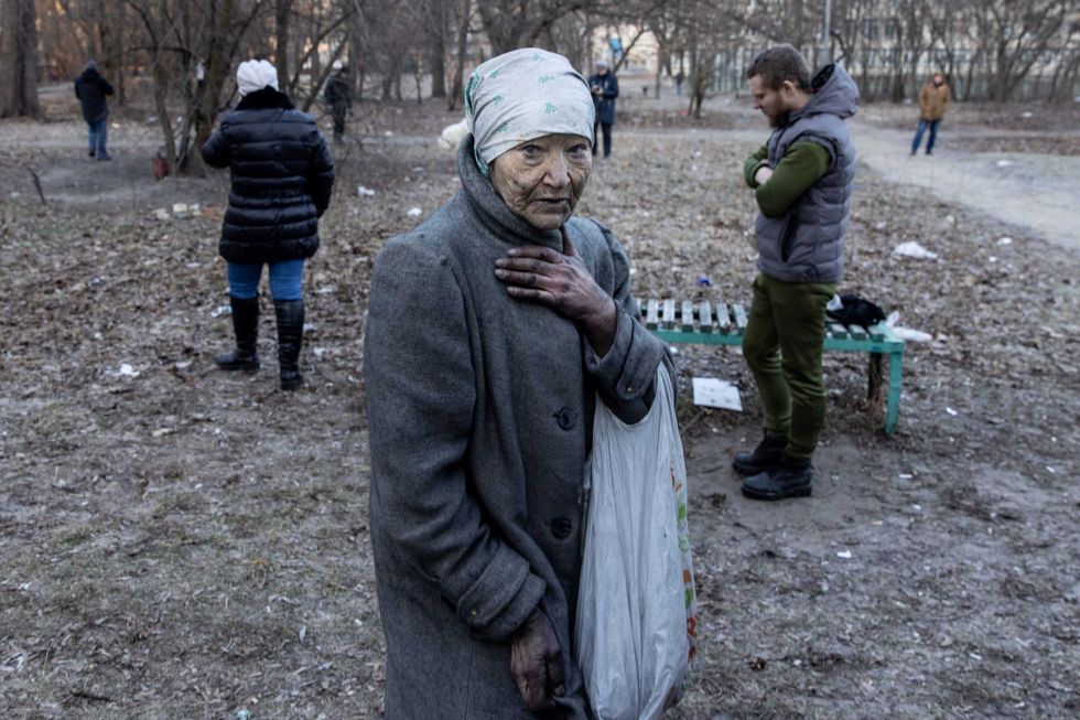 A resident reacts after being rescued from her apartment by firefighters at a residential apartment building after it was hit by a Russian attack in the early hours of the morning in the Sviatoshynskyi District on March 15, 2022 in Kyiv, Ukraine