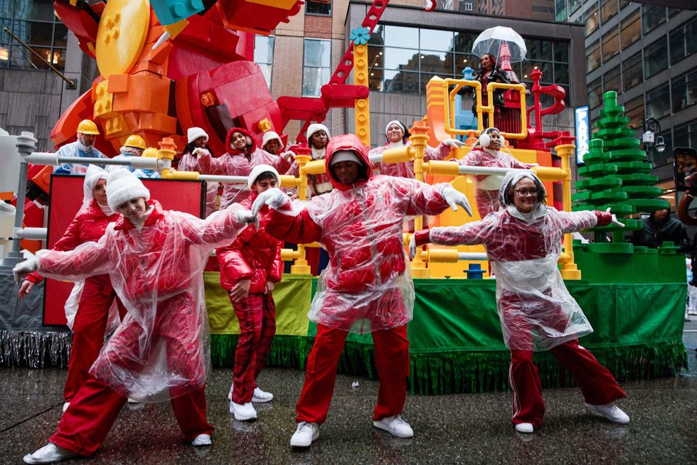 A reveller fix the dress from a mate as they march during the Annual Thanksgiving Day Parade on November 28, 2024 in New York City. This is the 98th Macy