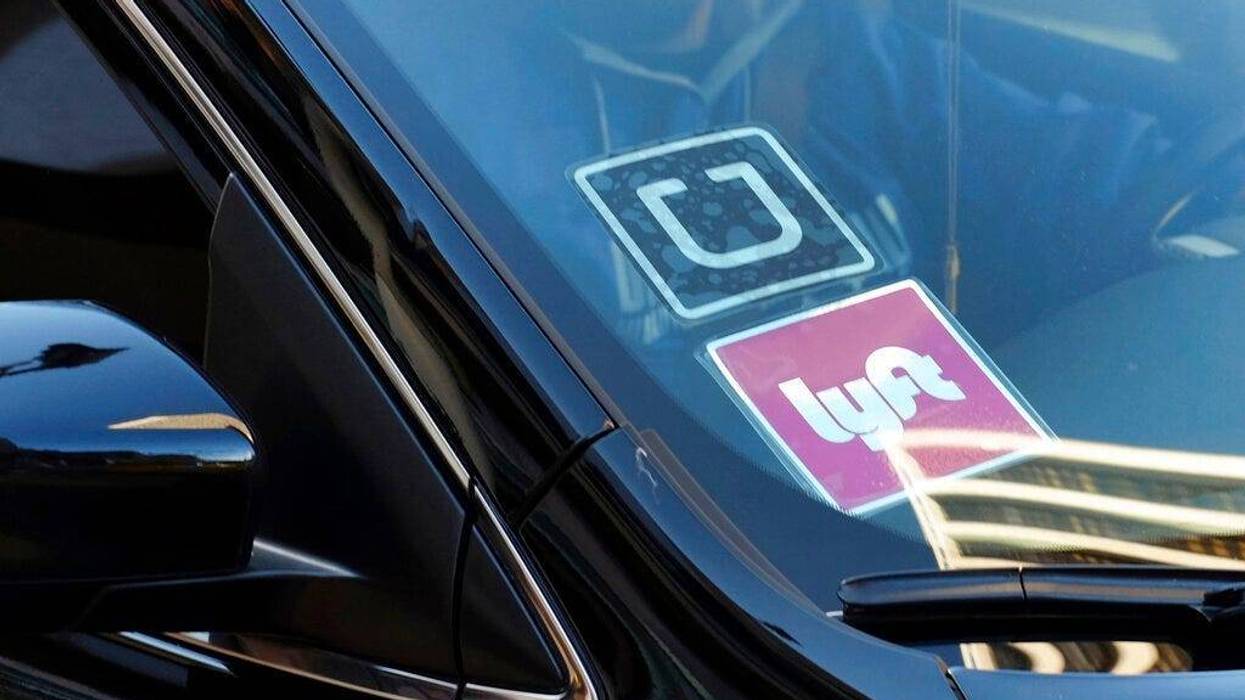 a ride share car displays Lyft and Uber stickers on its front windshield in downtown Los Angeles. Law enforcement agencies and ride-hailing companies are intensifying efforts to warn passengers against getting in without checking to ensure both the vehicl