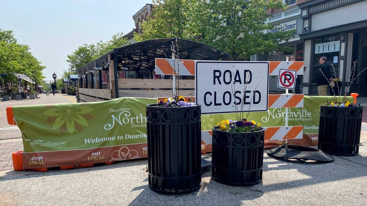 A road closed barrier blocks off a street for outdoor dining