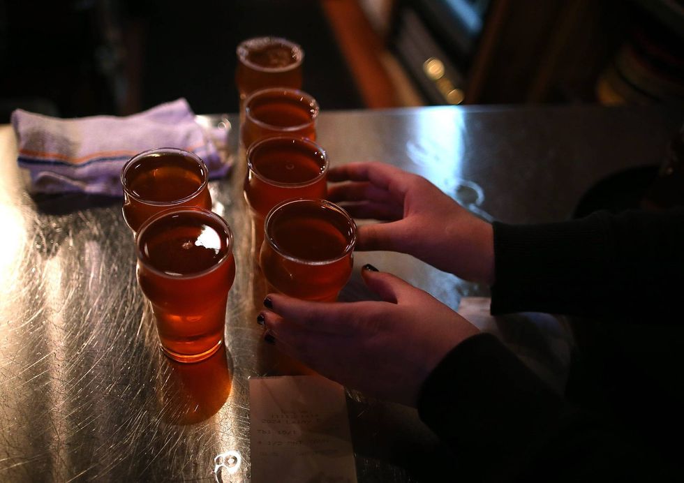 A Russian River Brewing Company server picks up glasses of the newly released Pliny the Younger triple IPA beer on February 7, 2014 in Santa Rosa, California.