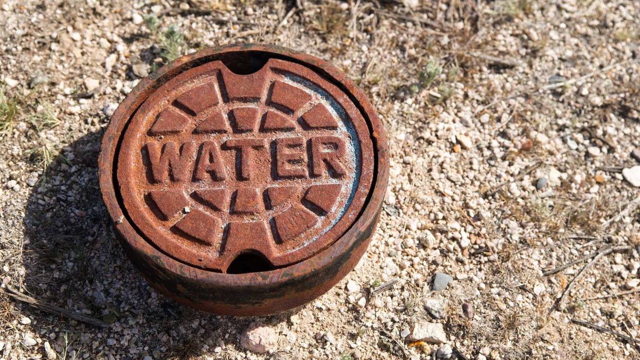 A rusted cast iron water main cover.