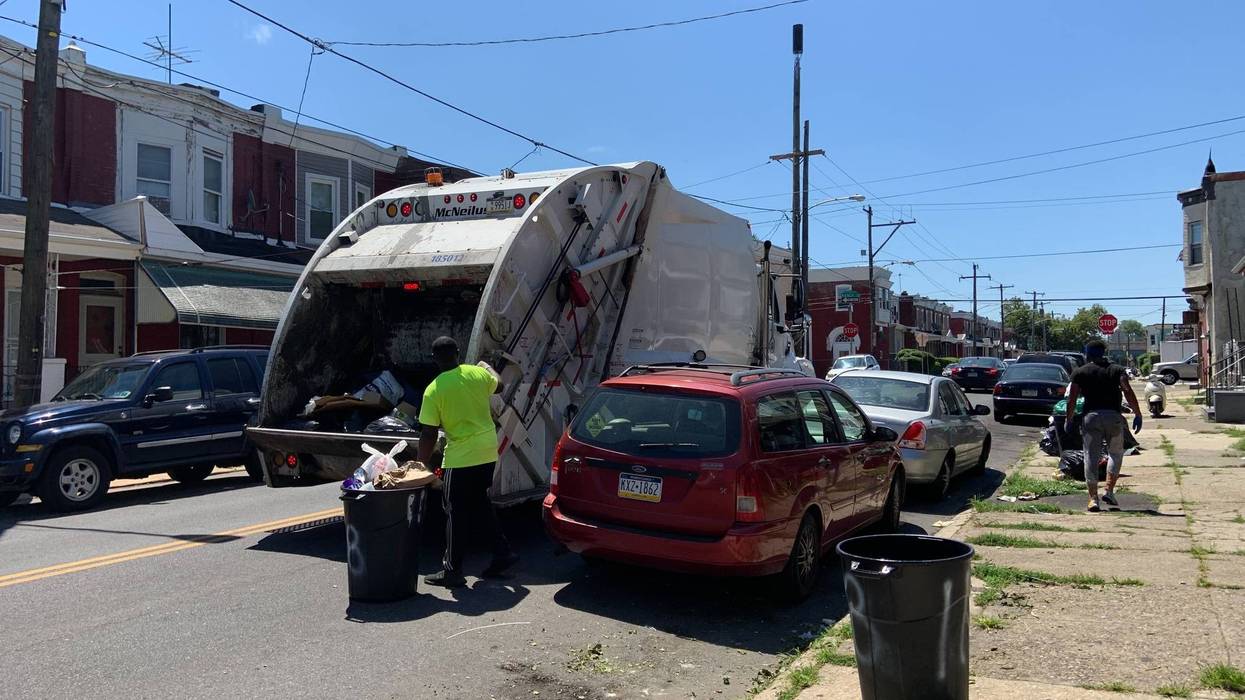 A sanitation truck collects trash near 58th and Arch Streets in West Philadelphia.