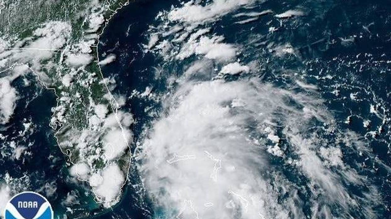 A satellite image shows a tropical depression spinning between the Bahamas and Florida. Depression