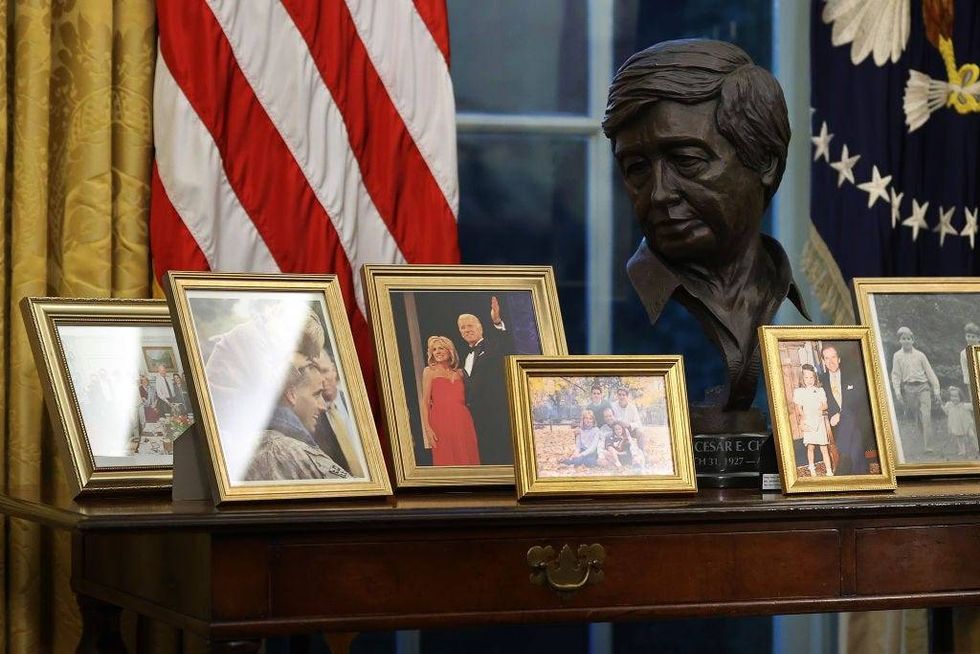 A sculpted bust of Cesar Chavez is seen with a collection of framed photos on a table as U.S. President Joe Biden prepares to sign a series of executive orders at the Resolute Desk in the Oval Office just hours after his inauguration on January 20, 2021 in Washington, DC. Biden became the 46th president of the United States earlier today during the ceremony at the U.S. Capitol.