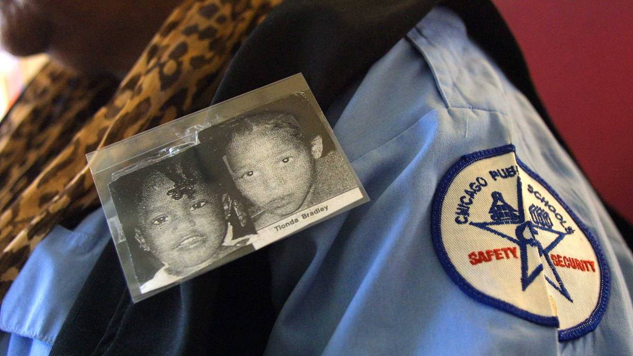 A security guard at Doolittle Primary School wears a photo of Tionda, right, and her younger sister Diamond Bradley July 12, 2001 in Chicago, IL. The sisters attended the school before they were reported missing on July 1.
