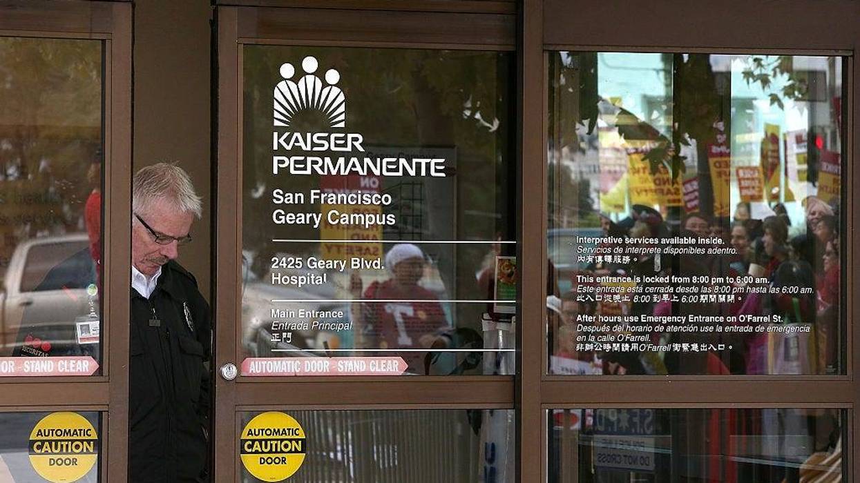 A security guard looks through a window as nurses strike outside of Kaiser Permanente hospital on November 11, 2014 in San Francisco, California.