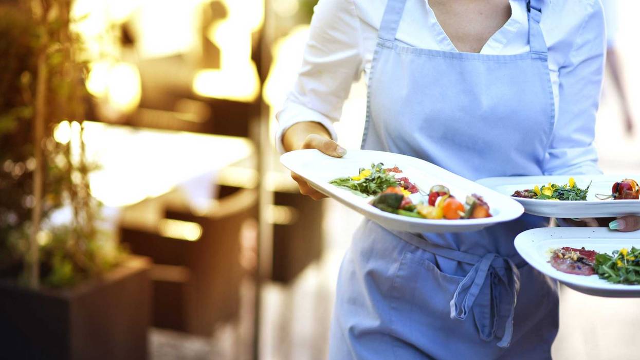 A server brings out plates of food.
