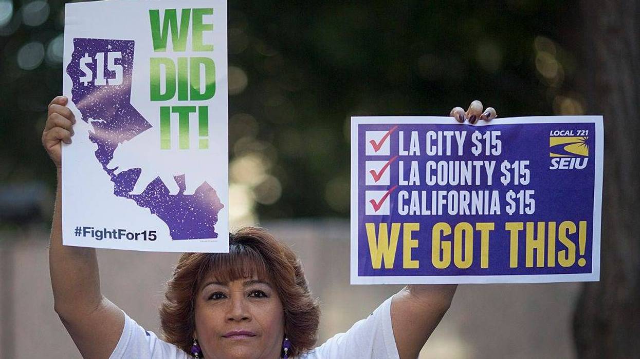 A Service Employees International Union member celebrates after California Governor Jerry Brown signed landmark legislation SB 3 into law on April 4, 2016 in Los Angeles, California.