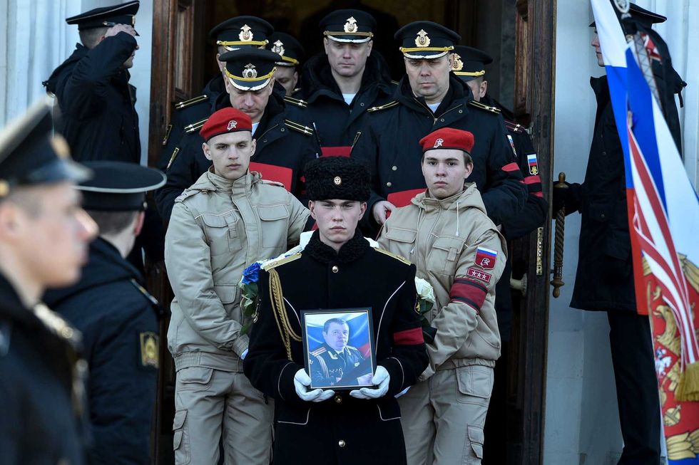 A serviceman carries the photo of Capt. Andrei Paliy, a deputy commander of Russia