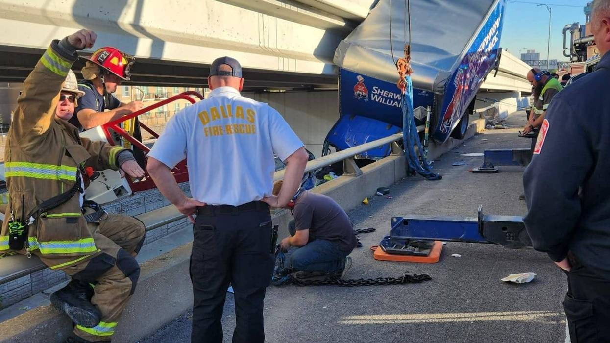 A Sherwin Williams truck hangs off a highway on Interstate 35E in Dallas on Monday, Dec. 4, 2023.