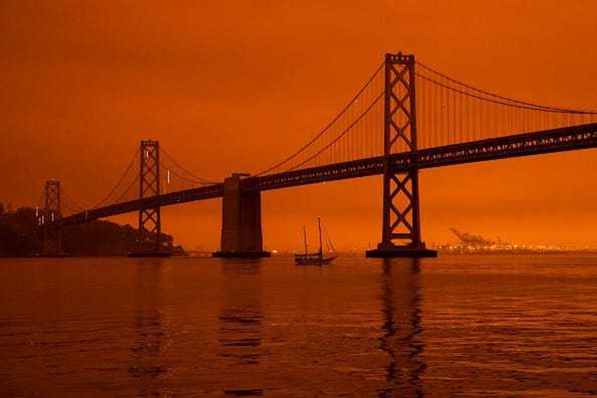 A ship passes beneath the Bay Bridge as smoke from various wildfires burning across Northern California mixes with the marine layer, blanketing San Francisco in darkness and an orange glow on September 9, 2020 in San Francisco,