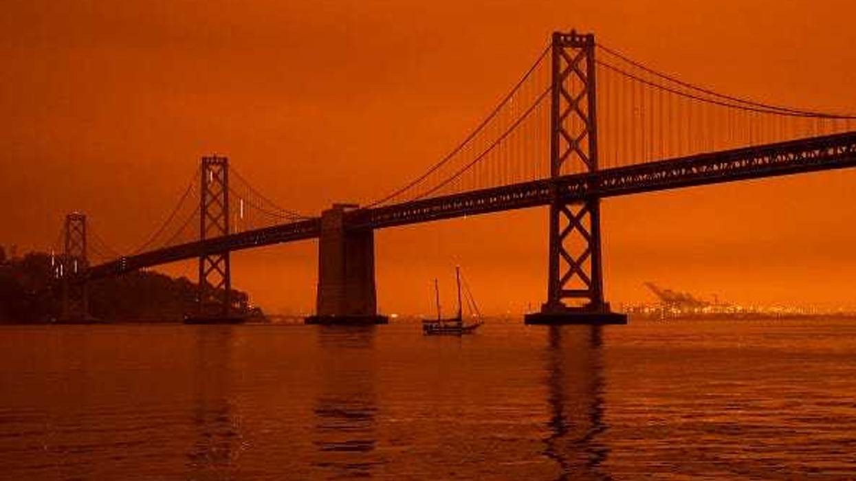 A ship passes beneath the Bay Bridge as smoke from various wildfires burning across Northern California mixes with the marine layer, blanketing San Francisco in darkness and an orange glow on September 9, 2020 in San Francisco,