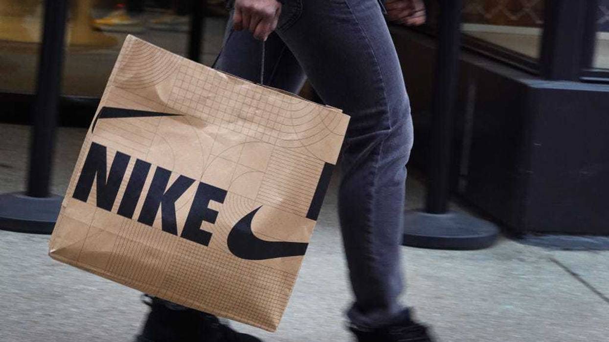 A shopper carries a bag of Nike merchandise along the Magnificent Mile shopping district on December 21, 2022 in Chicago, Illinois.