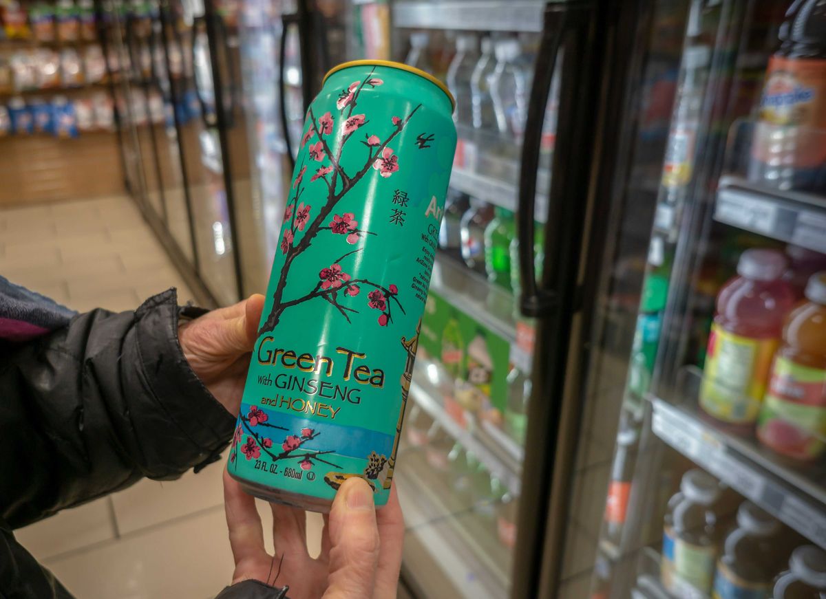 A shopper chooses a can of AriZona Iced Tea’s Green Tea with Ginseng and Honey in a convenience store in New York on Monday, April 22, 2019.