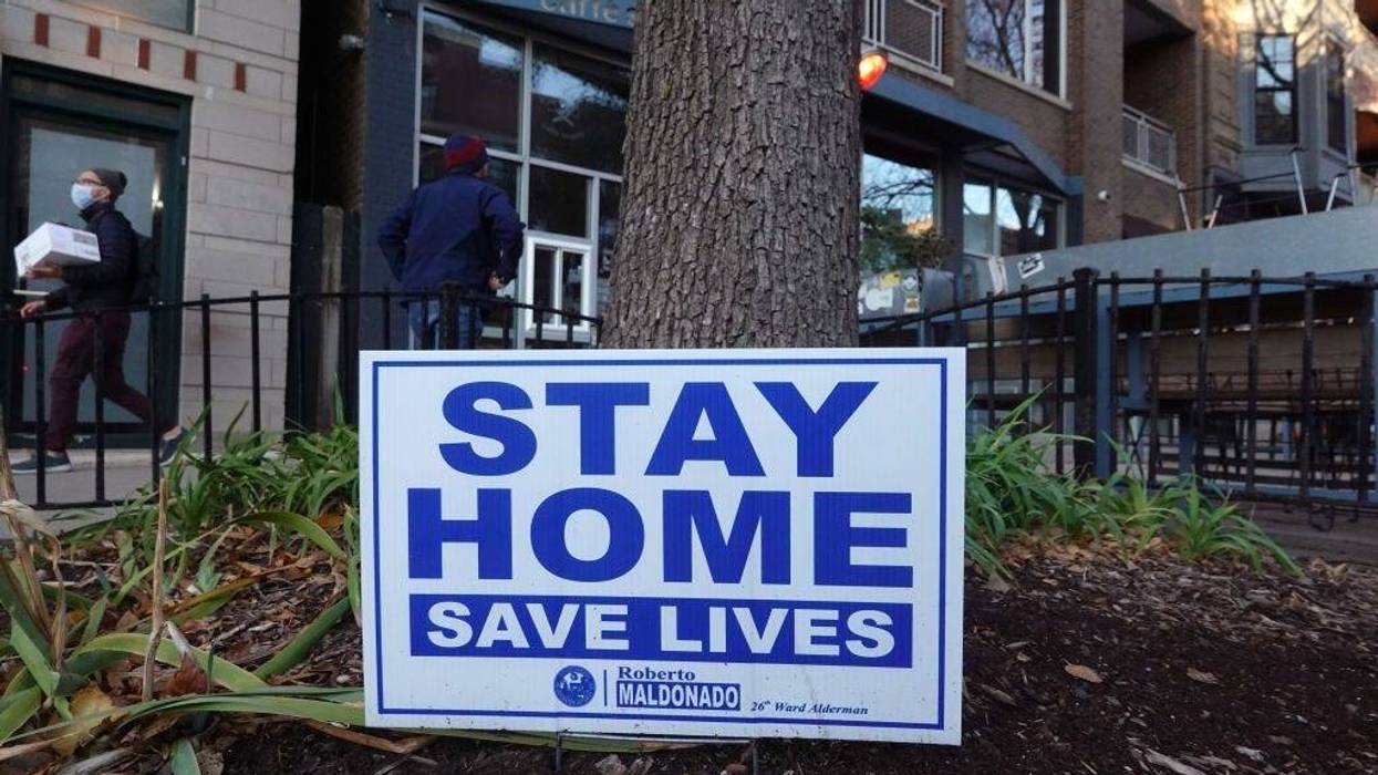 A sign along the sidewalk in an area lined with bars and restaurants in the Wicker Park neighborhood encourages people to stay home on November 11, 2020 in Chicago, Illinois.