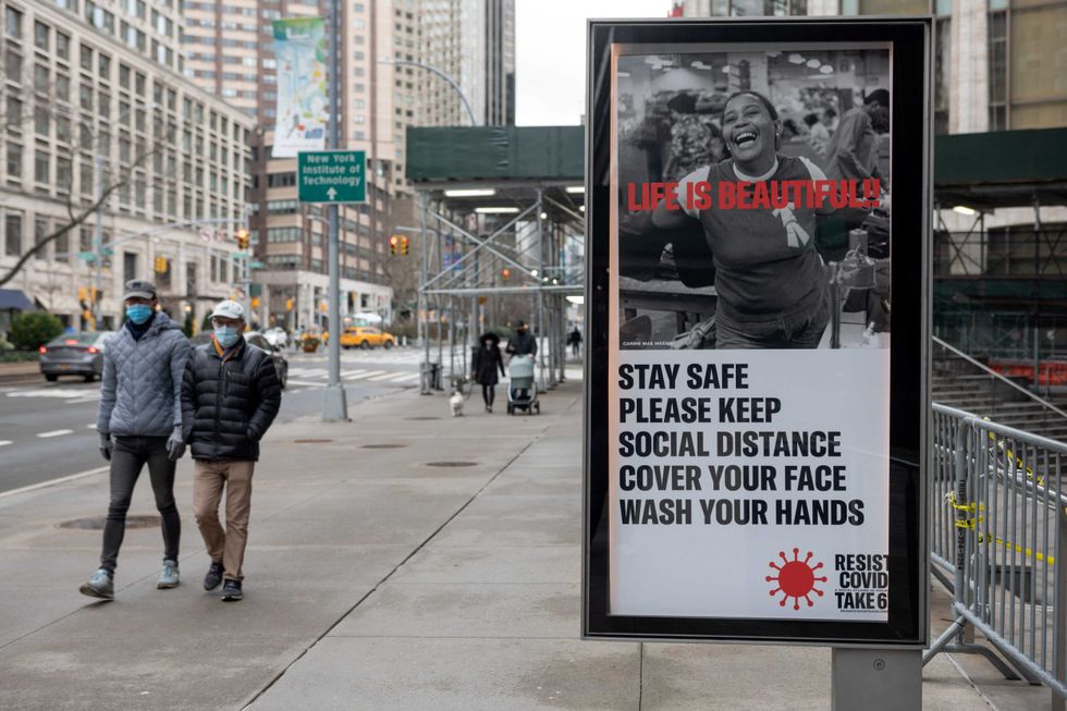 A sign asks people to "stay safe, please keep social distancing, cover your face, wash your hands" at Lincoln Center for The Performing Arts on December 25, 2020 in New York City. The pandemic has caused long-term repercussions throughout the tourism and entertainment industries, including temporary and permanent closures of historic and iconic venues, costing the city and businesses billions in revenue.