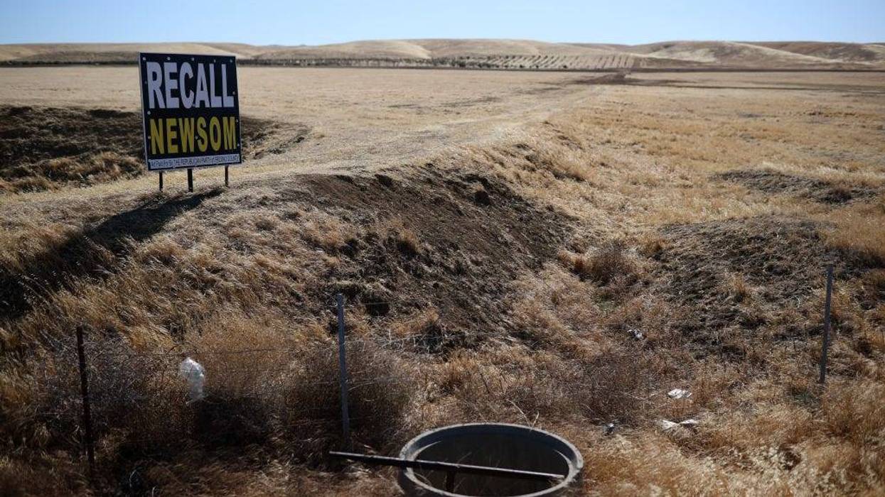 A sign calling for the recall of California Gov. Gavin Newsom is posted next an agricultural field that lies fallow on May 25, 2021 in Firebaugh, California.