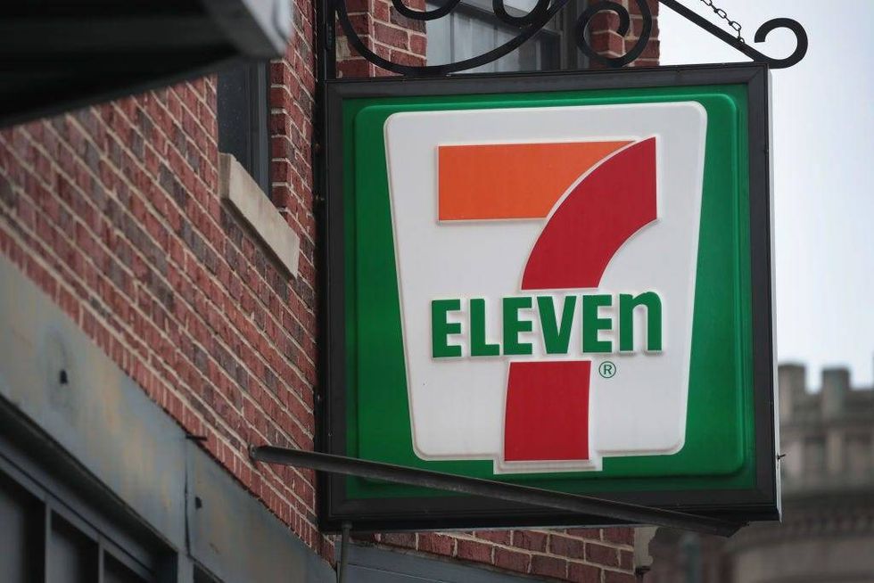 A sign hangs outside of a 7-Eleven store
