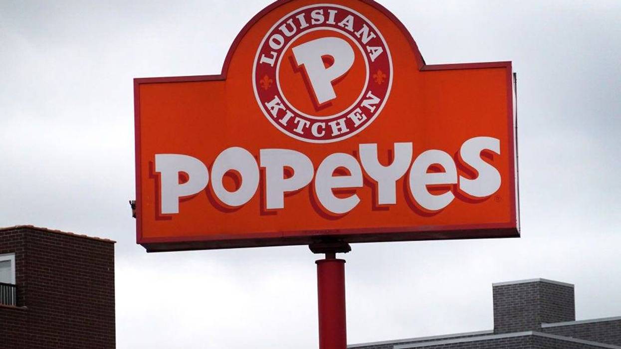 A sign hangs outside of a Popeyes Louisiana Kitchen restaurant