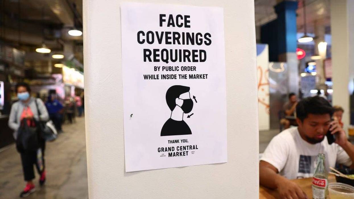 A sign is posted about required face coverings in Grand Central Market on July 19, 2021, in Los Angeles.