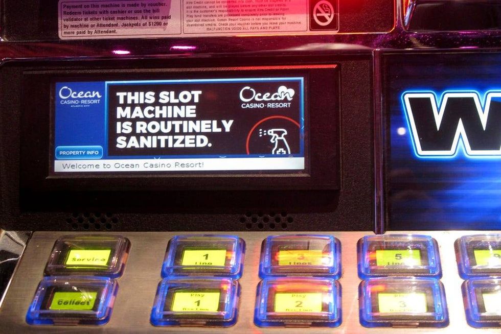 A sign on a slot machine at Ocean Casino Resort in Atlantic City, New Jersey, indicates it would be routinely sanitized after the casino reopens a month later.