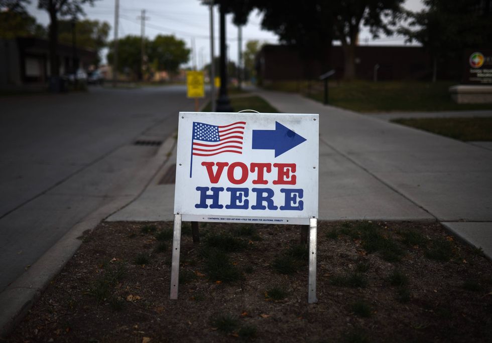 A sign reading "Vote Here" points toward a polling place for the 2018 Minnesota primary election at Holy Trinity Lutheran Church on August 14, 2018 in Minneapolis, Minnesota.