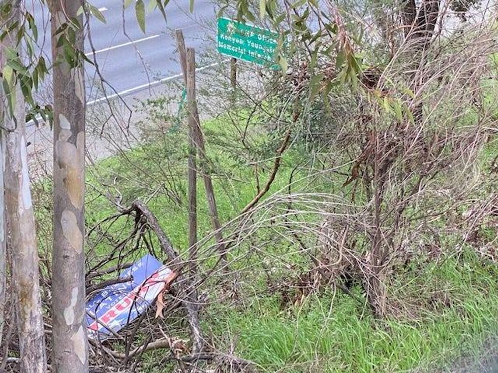 A sign supporting President Trump lays discarded by the site of a recurring pro-Trump protest