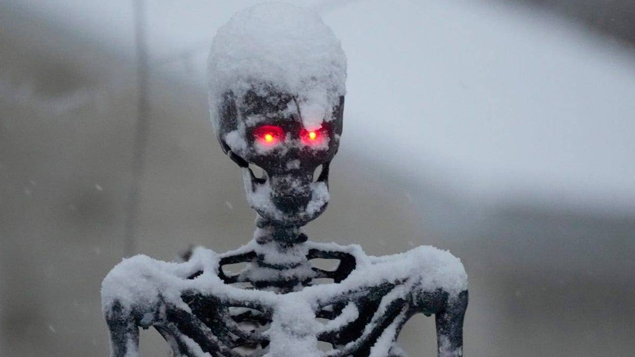 A skeleton is covered in snow as the first snow falls across the area on Halloween